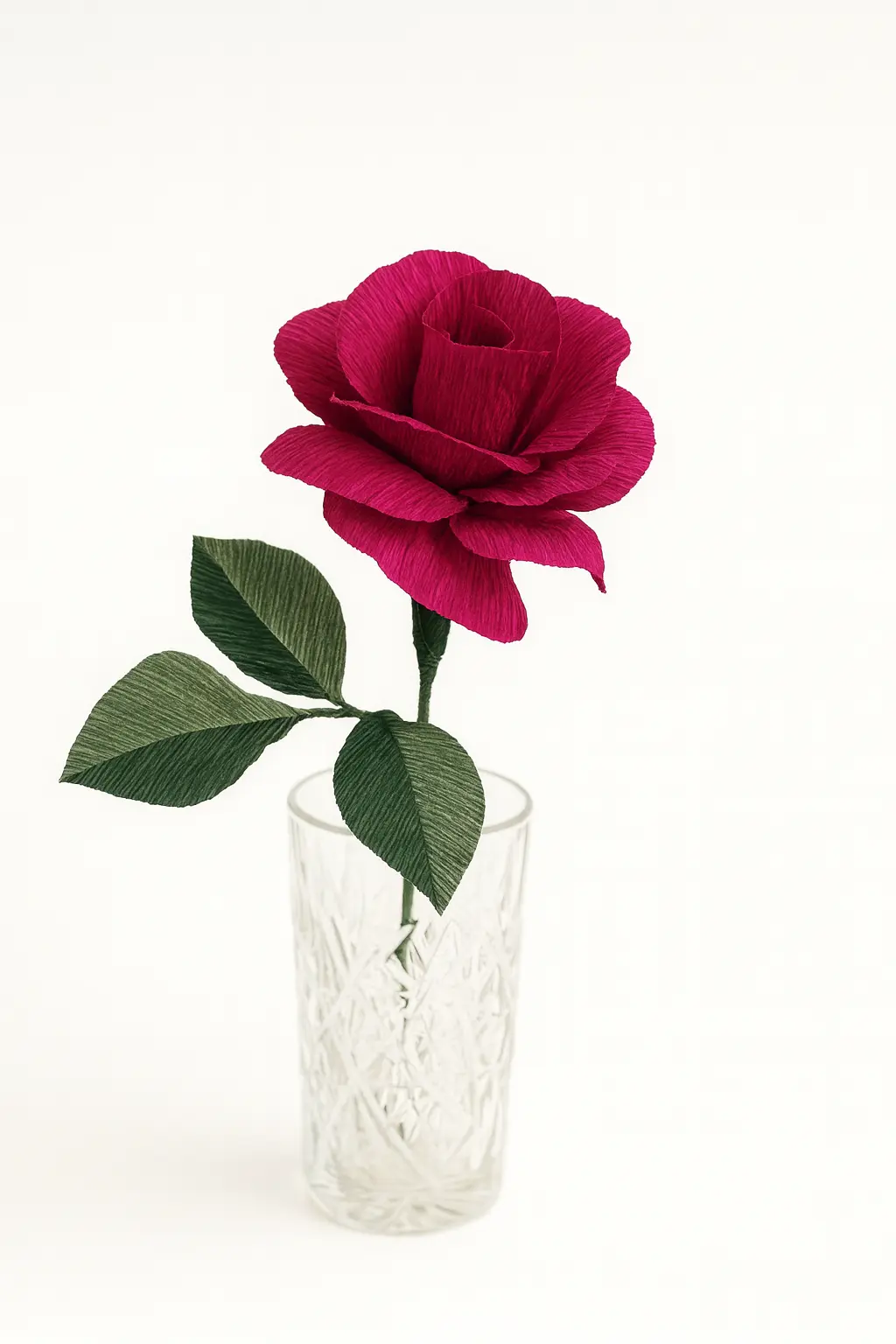 Vinrød Håndlavet Papirrose – Romantisk og Tidløs Dekoration Vinrød/mørkerød papirrose i crepepapir, placeret i et klart glas.